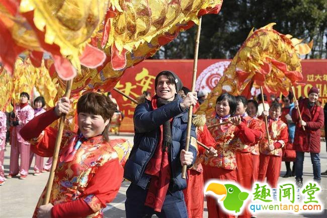 2月4日，来自波兰的米罗（前左二）与村民一起舞奉化布龙。春节临近，近100位外国友人应邀来到浙江省宁波市奉化区尚田镇鸣雁村，体验舞龙、写春联、打年糕、剪窗花等传统民俗活动，迎接新春佳节。   新华社记者 黄宗治 摄