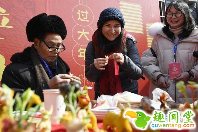 2月4日，来自印度的萨西（中）在手艺人的指导下学习米塑捏花草。春节临近，近100位外国友人应邀来到浙江省宁波市奉化区尚田镇鸣雁村，体验舞龙、写春联、打年糕、剪窗花等传统民俗活动，迎接新春佳节。   新华社记者 黄宗治 摄