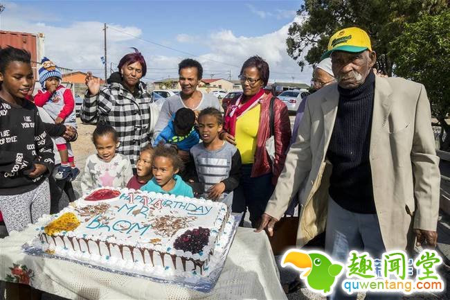 5月8日，在南非开普敦市郊德尔福特，弗雷迪·布洛姆（右一）与亲友庆祝自己114岁生日。生活在南非开普敦市郊德尔福特的老人弗雷迪·布洛姆8日迎来114岁生日。与往年不一样的是，当天为他祝寿的不仅有妻子、儿女及邻居，还有西开普省社会发展部长弗里茨以及多家媒体记者，非常热闹。新华社发（威廉·穆维摄）